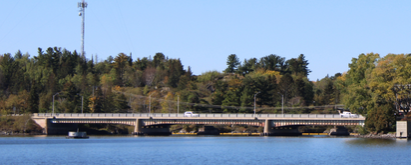 bridge, water, trees, and blue sky with Asset Management Plan Questionnaire text 